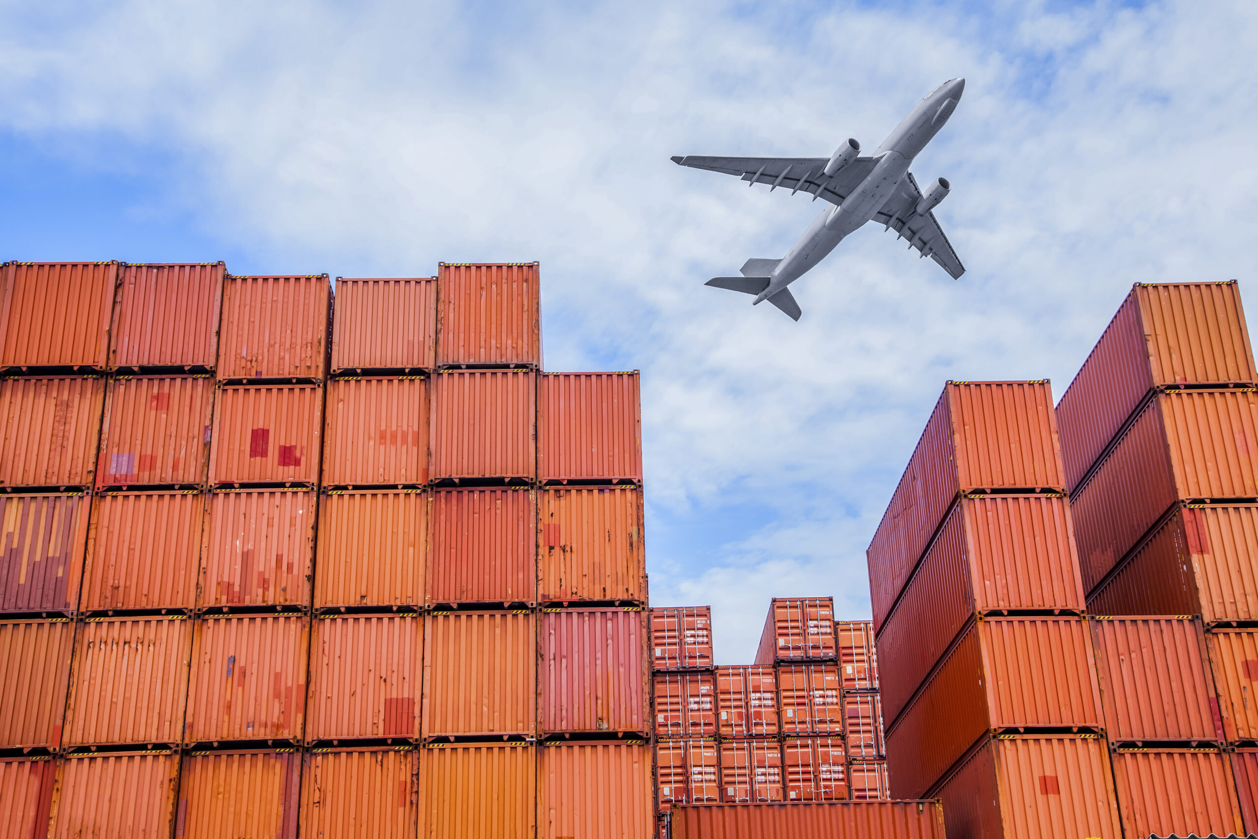 Aircraft flying above shipping containers